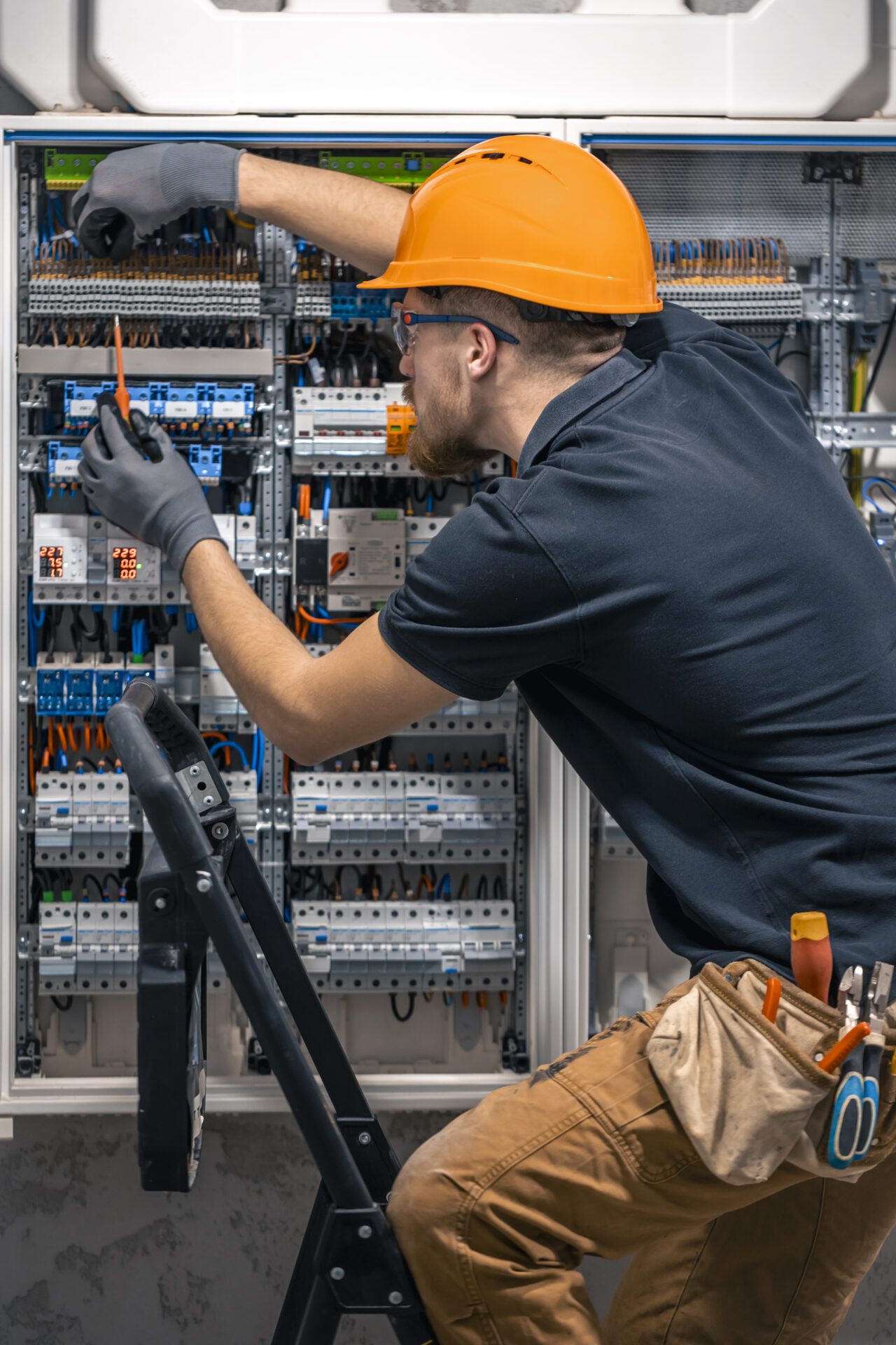 Male electrician working in a switchboard with fuses. Male electrician working in a switchboard with fuses<br />